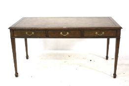 An Edwardian oak writing table with inset leather top.