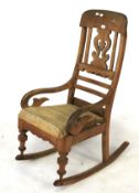 A Victorian walnut hard seat rocking chair.