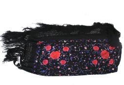 A flamenco dancer's embroidered shawl. Decorated with flowers on a black woven ground with tassels.