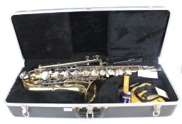A saxophone and stand. Buescher Aristoctrat 200 USA, in case.
