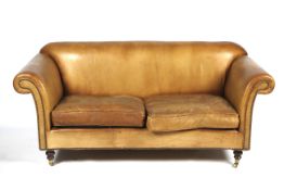 A two-seater tan leather sofa.
