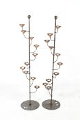 A pair of contemporary floor standing metal and copper tealight holders.