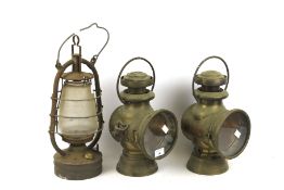 A pair of vintage Lucas brass car head lamps and a storm lantern. The first 'King of the Road'.