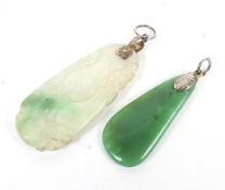 Two jade pendants. One green and the other white and carved with a flash of green.