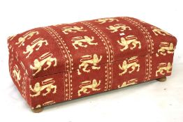 An upholstered Ottoman. red with white lion pattern on wooden feet, H43cm x D57cm W124cm.