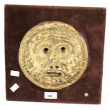 A mid-20th century pottery roundel face. Mounted on wooden board with red upholstery, H30cm x W30cm.