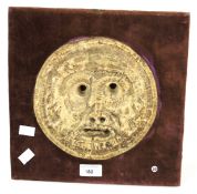 A mid-20th century pottery roundel face. Mounted on wooden board with red upholstery, H30cm x W30cm.