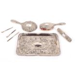 A silverplated tray with embossed decoration and a silver back dressing table set.
