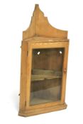 A Victorian pine corner cupboard. With a glazed door opening to reveal a single shelf, L59cm x D40.