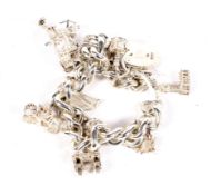 A silver curb link charm bracelet and ten assorted charms. 85.5 grams.