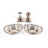 A pair of pierced white metal bon bon dishes and a pair of heavy metal post finial paper weights.