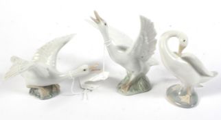 Three Lladro geese in various poses. Two flapping their wings and one grooming, H14cm.