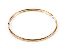 A 9ct gold bangle, engraved with a chevron pattern, 5.