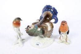 A group of three assorted china birds figurines.