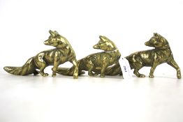 Three brass models of foxes. In naturalistic poses, L20.