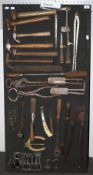 A collection of assorted vintage Farrier tools on a display board.