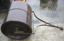 A vintage garden roller with wrought iron shaft.