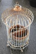A wirework bird cage ornament and two terracotta pots.