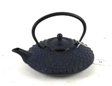 A cast iron Japanese squat teapot and cover.