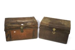 Two vintage riveted tin travelling trunks.