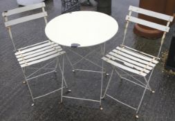 Two white metal folding metal chairs garden chairs and a table.