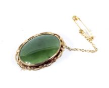 A vintage nephrite-jade oval brooch. The oval cabochon approx. 25mm x 18.