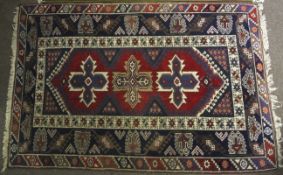A Persian style rug. Blue and red ground with geometric pattern.