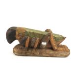 A large Indonesian carved and stained wooden figure of a grasshopper or cricket.