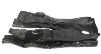 Two pairs of black leather motorcycle trousers.