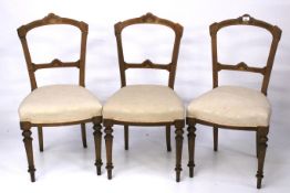 A set of three inlaid mahogany upholstered dining chairs.
