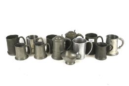 A collection of twelve assorted pewter items. Including tankards, etc.