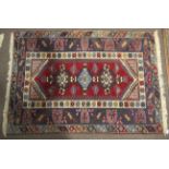 A Persian style rug. Blue and red ground with geometric pattern.