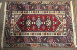 A Persian style rug. Blue and red ground with geometric pattern.