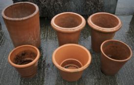 Six large terracotta plant pots.