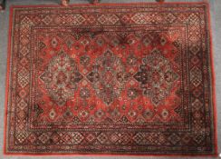 A woolen machine-made Eastern style rug on red ground.