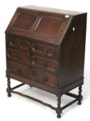 A Victorian oak bureau. On barley twist supports with serpentine stretcher.