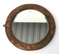 A copper framed wall mirror.