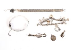An assortment of silver jewellery. To include a charm bracelet, bangle, gate bracelet, 96.8 grams.