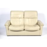 A contemporary cream leatherette upholstered adjustable two-seater sofa. L163cm x D73.