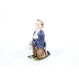 A German Goeble figure of a boy kneeling with a lamb. H15.5cm, marks to the base.