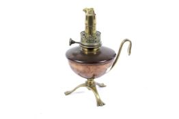 An Art Nouveau copper and brass hand held oil lamp by W A S Benson.