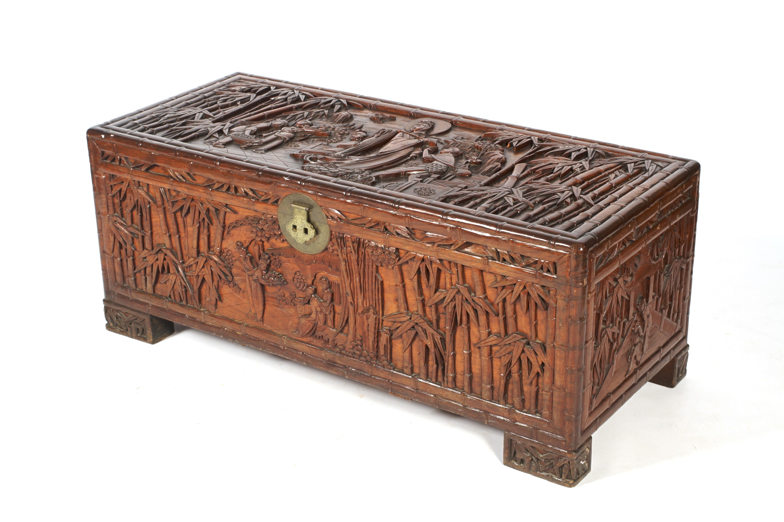 A Chinese carved camphor wood chest. Carved with figures amongst bamboo.