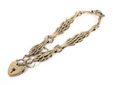 A vintage gold fancy gatelink bracelet on a heart-shaped padlock clasp.