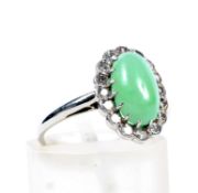 An early/mid-20th century white gold, jadeite and diamond oval cluster ring.