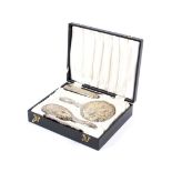 A silver mounted three piece dressing table set, in a case.