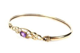 A modern 9ct gold and amethyst single stone bangle.