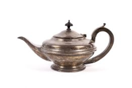 A silver round teapot. With a moulded band, an ebonised handle and finial on a stepped foot.
