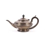 A silver round teapot. With a moulded band, an ebonised handle and finial on a stepped foot.