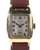 A gentleman's 9ct gold tonneau-shaped wristwatch. Circa 1934, the silvered dial signed 'J. W.