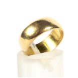 An Edwardian 22ct gold broad wedding band. Of shallow 'D' section, 6.